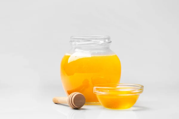 Organic Honey Glass Jar Transparent Bowl Wooden Dipper White Background — Zdjęcie stockowe