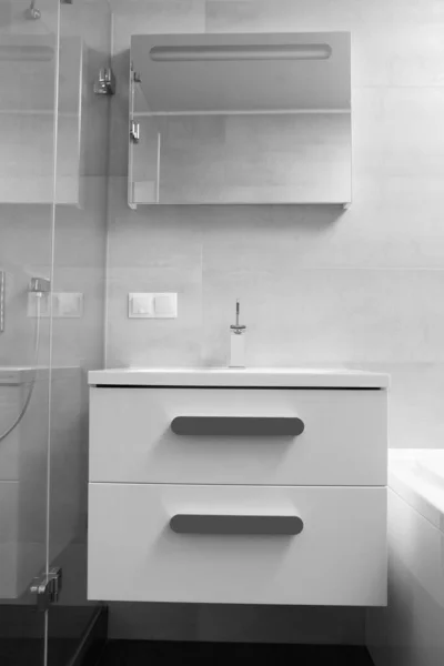 モダンなバスルーム キャビネットと引き出し付きの白い洗面台 クロム蛇口 大きな照明ミラー ガラスシャワーキャビンのインテリアの一部 浴室のデザイン — ストック写真