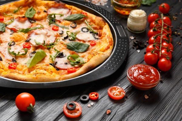 Pizza Met Jerky Olijven Kaas Kruiden Een Zwarte Ronde Bakvorm — Stockfoto