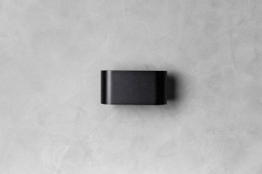 Gri desenli duvarda, yazı için yeri olan modern siyah bir lamba. Gri arkaplan kopyalama alanı üzerindeki LED lamba