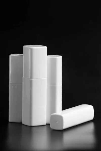 一套用于面部护肤化妆品的白色塑料瓶 在黑色背景下隔离 用抽水机和瓶盖包装奶油 品牌身份模拟概念 — 图库照片