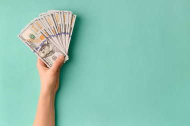 100 dolarlık banknotların çoğu yeşil arka plan manzaralı bir vantilatörde katlanmış ve mesaj için boşluk bırakılmış. Para, banknotlar kadınların elinde. Başarı, iş, zenginlik kavramı.