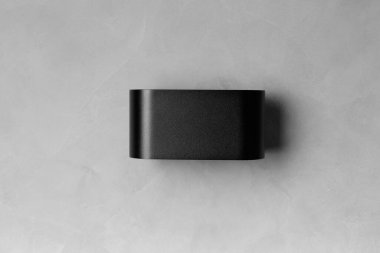 Gri desenli duvarda, yazı için yeri olan modern siyah bir lamba. Gri arkaplan kopyalama alanı üzerindeki LED lamba