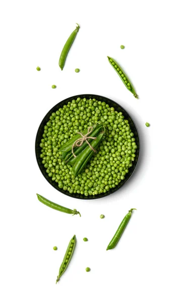 白い背景に丸い黒いプレートと緑のエンドウ豆のポッドで新鮮な緑のエンドウ豆の皮をむいた穀物 トップビュー 植物性タンパク質健康的な製品 — ストック写真