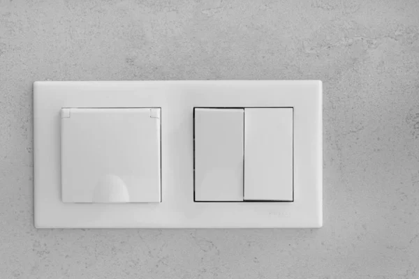 Closed socket and switch on porcelain stoneware in the bathroom