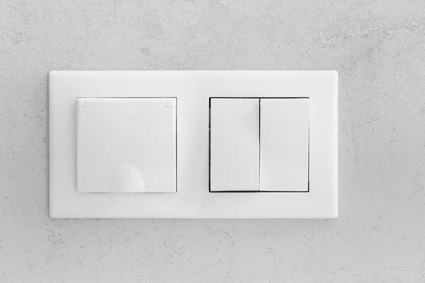 Closed socket and switch on porcelain stoneware in the bathroom
