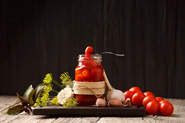 Marynowane Pomidory Wiśniowe Otwartym Słoiku Ciemnej Drewnianej Desce Jeden Pomidor — Zdjęcie stockowe