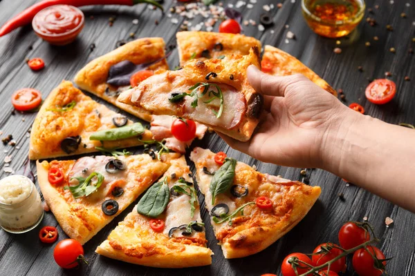 Handen Nemen Plakjes Gesneden Pizza Een Donkere Houten Achtergrond Bovenaanzicht — Stockfoto