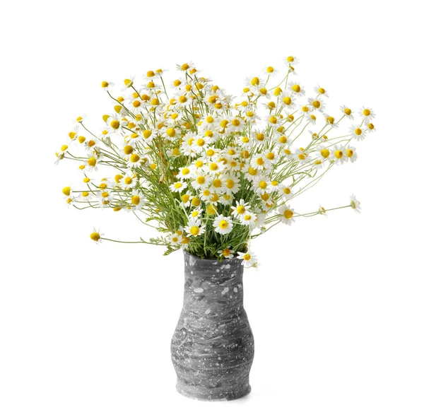 A beautiful large bouquet of field daisies in a gray handmade clay vase on a white background. Bouquet of wild flowers on white isolated.