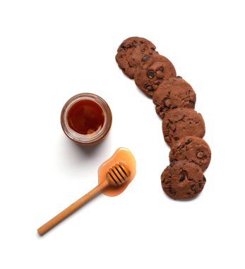 Kavramsal kompozisyon bal bir kase, Dipper, ev yapımı çikolatalı kurabiyeler beyaz arka planda düz bir görünüm yatıyordu..