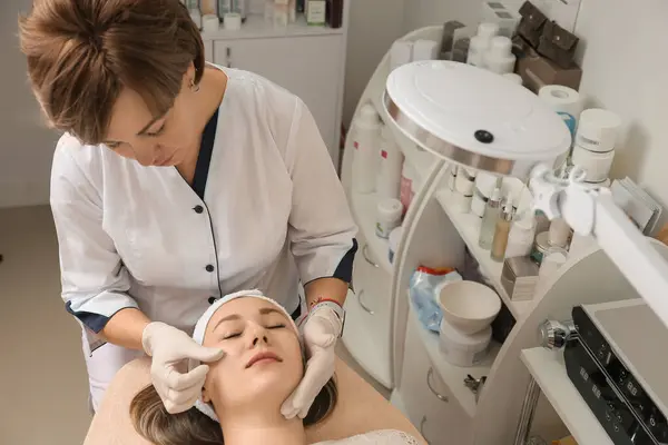 Face and body treatments. The concept of maintaining health, youth and beauty. Face masks, face massage, modern cosmetology, beautician tools, hands with gloves. Beauty techniques.
