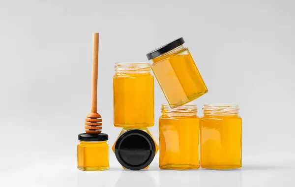 Conceptual Composition Glass Jars Form Honeycombs Honey Wooden Dipper White — Stock Photo, Image
