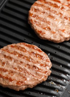 Hamburger için biftek köfteleri akıllı elektrikli ızgarada kızartılır. Ev yapımı hamburgerler. Hamburger malzemeleri..