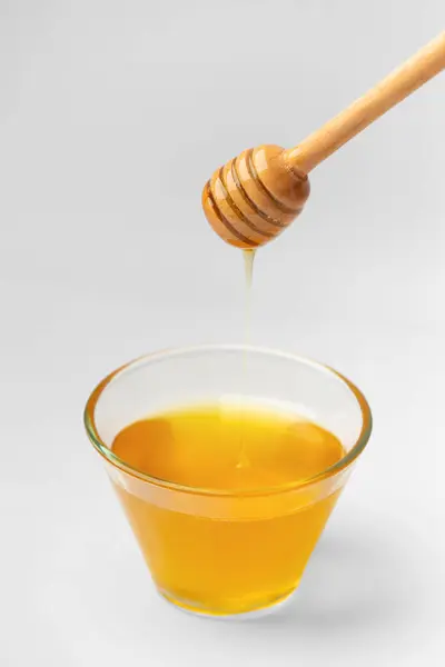 Organic Honey Poured Dipper Glass Transparent Bowl Close White Background lizenzfreie Stockbilder
