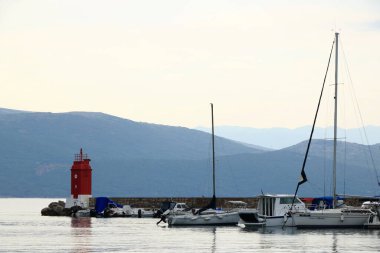 Krk limanındaki deniz feneri ve botlar, Krk Adası, Hırvatistan