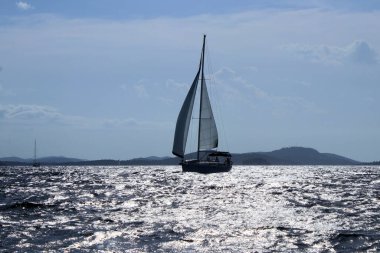 Bir yelkenlinin güzel kombinasyonu ve güneşin yansıması, Murter Adası, Hırvatistan