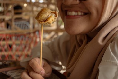 The girl smile when eating the traditional snack 