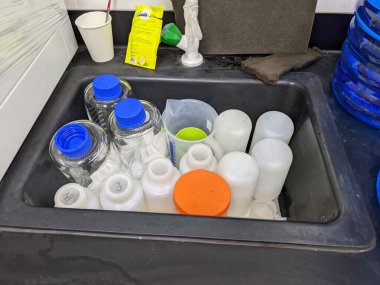 Lot of bottle sample on the sink laboratory, after chemical cleaning. The photo is suitable to use for laboratory background, analysis poster and content media.