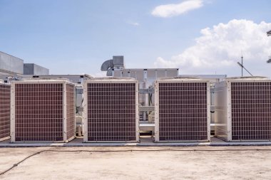 Array of outdoor fan air conditioner on the roof top building. The photo is suitable to use for construction and maintenance of air conditioner.