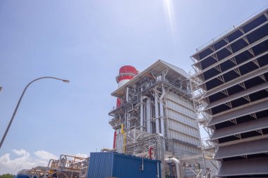 aerial view of combine cycle project power plant when day time with blue sky and cloudy vibes. The photo is suitable to use for industry background photography, power plant poster and electricity.