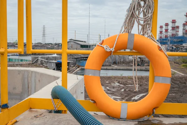 Safety flotation ring on water storage and water treatment area, for emergency action. The photo is suitable to use for safety background photography, power plant poster and electricity content media.