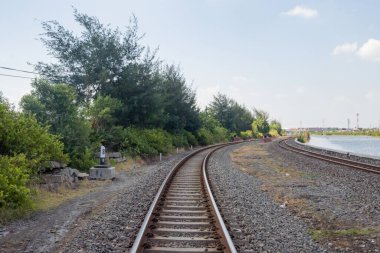 Mavi gökyüzü ve gölü olan sanayi bölgesinde demiryolları var. Fotoğraf demiryolu arkaplanı, demiryolu içeriği medyası ve seyahat afişi için uygun.