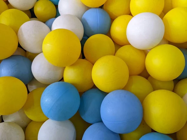 Lot of small ball on kids playground, blue, yellow and white. The photo is suitable to use for playground background, kids toys content media and bath ball poster.