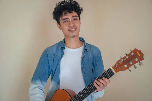 Jovem Homem Encaracolado Usa Roupas Ganga Tocando Guitarra Sorria Feliz — Fotografia de Stock