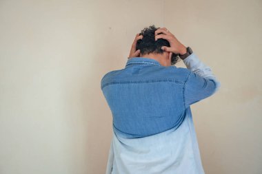 Genç kıvırcık adam depresyon yüzlü kot pantolon giyiyor. Bu fotoğraf, erkek ifadesi reklamcılığı ve moda yaşam tarzı için uygun..