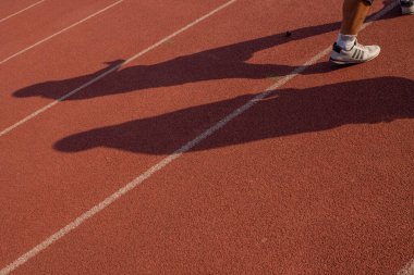 Gölge ve ayakçıyla koşmak için koşu pisti. Fotoğraf spor ve içerik ortamını çalıştırmak için uygundur.