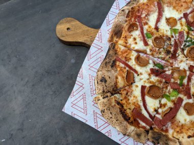 Gri masanın üzerinde mantarlı baharatlı pizza. Fotoğraf yemek içeriği medyası ve abur cubur afişi için kullanılabilir.