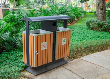 Bahçedeki çöp tenekesi organik çöp ve organik olmayan çöp. Fotoğraf çevre ve halka açık park içeriği için kullanılabilir.