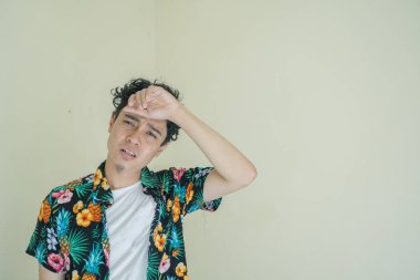 Kıvırcık adam Endonezyalı plaj kıyafetlerini giyer ve terler. Bu fotoğraf, erkek ifadesi reklamcılığı ve moda yaşam tarzı için uygun..