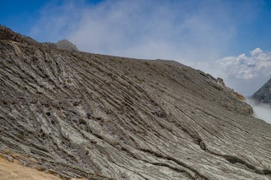 İjen Dağı volkanik krateri gündüz vakti mavi ateş ve göl. Fotoğraf macera içeriği medyası, doğa posteri ve orman geçmişi için kullanılabilir.