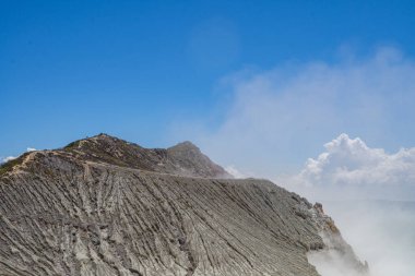 İjen Dağı volkanik krateri gündüz vakti mavi ateş ve göl. Fotoğraf macera içeriği medyası, doğa posteri ve orman geçmişi için kullanılabilir.