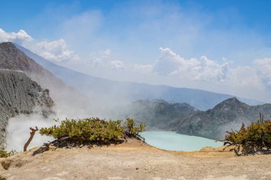 İjen Dağı volkanik krateri gündüz vakti mavi ateş ve göl. Fotoğraf macera içeriği medyası, doğa posteri ve orman geçmişi için kullanılabilir.