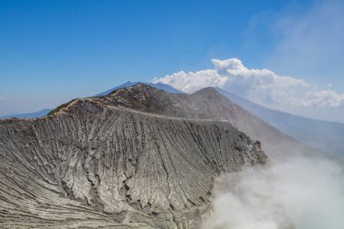 İjen Dağı volkanik krateri gündüz vakti mavi ateş ve göl. Fotoğraf macera içeriği medyası, doğa posteri ve orman geçmişi için kullanılabilir.