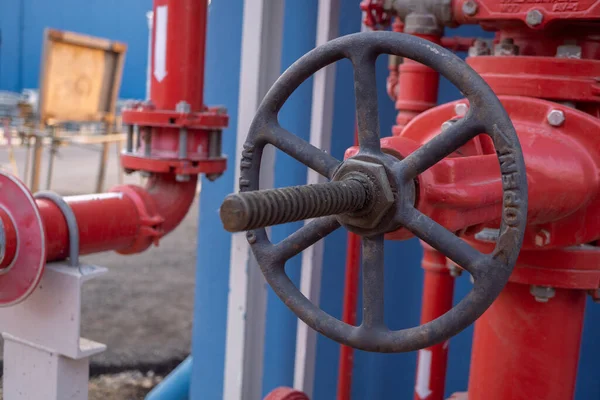 Manual gate valve on the water distribution pipe line on the power plant. The photo is suitable to use for industry background photography, power plant poster and electricity content media.
