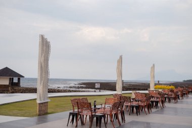 Boş sandalye ve güzel bir arka planı olan masa ve restoranda bulutlu bir gökyüzü. Fotoğraf seyahat, tatil ve tatil içeriği ortamını kullanmak için uygundur.