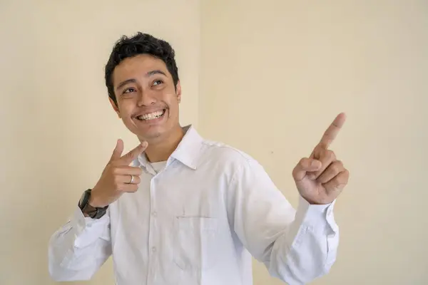 若いインドネシアのカーリー男性は サムネイルポーズで白い服を着ています 写真は 男性の表現広告やファッションライフスタイルに使用するのに適しています — ストック写真