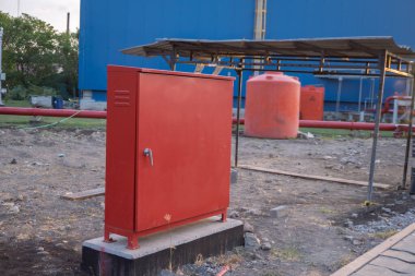 Açık hava yangın musluğu kutusu, beyaz hortum, hortum ve vanayla elektrik santrali alanında. Fotoğraf endüstri geçmişi ve itfaiyeci içeriği medyası için kullanılabilir.