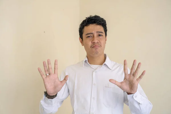 Genç Endonezyalı kıvırcık adam beyaz elbiseler giyiyor. Bu fotoğraf, erkek ifadesi reklamcılığı ve moda yaşam tarzı için uygun..