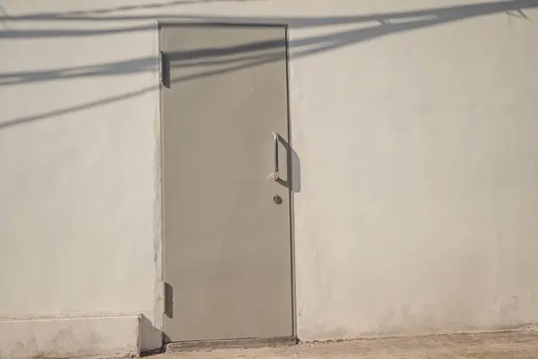 Gri renkli ve beyaz duvarlı metal kapalı kapı. Fotoğraf duvar kağıdı içeriği ortamı için kullanılabilir.