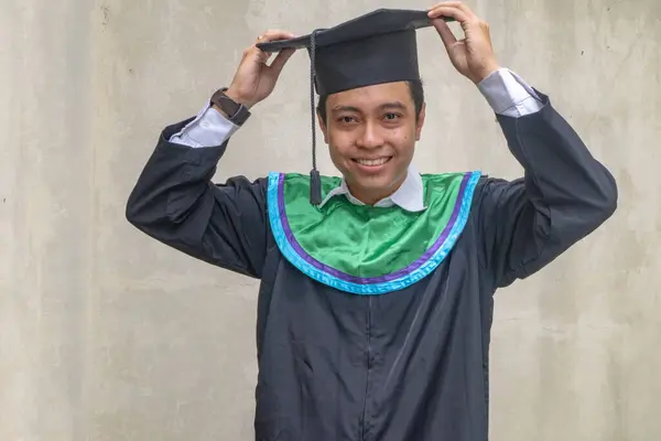 Young Indonesian guys celebration and cheers when graduation moment. The photo is suitable to use for education promotion and academic poster.