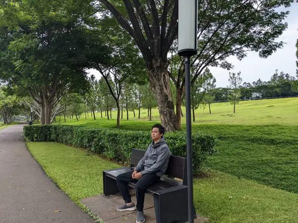 Muž Sedí Zeleném Parku Dole Městě Fotografie Vhodná Pro Klidnou — Stock fotografie