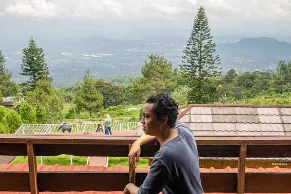 Άνθρωπος Κάθεται Κοντά Στο Φράχτη Και Κοιτάζει Βουνό Τοπίο Φωτογραφία — Φωτογραφία Αρχείου