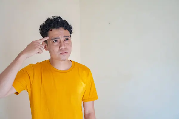 Молодой Человек Носит Желтую Футболку Мыслящей Позой Выражения Лица Фотография — стоковое фото