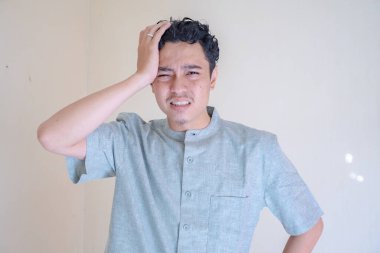 Müslüman Asyalı adamın başı dönüyor ve Ramazan kutlamalarında başı ağrıyor. Fotoğraf Ramadhan posteri ve Müslüman içerik medyası için uygun.