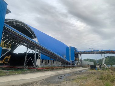 Kömür yatakhanesinin, kömür santrali projesinde şerit taşıyıcısı olan manzarası. Fotoğraf endüstri arka plan fotoğrafçılığı, elektrik santrali posteri ve bakım içeriği medyası için kullanılabilir.