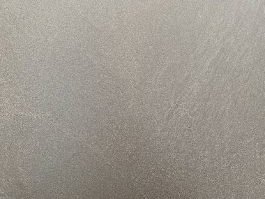 Kalıplı, gri bir yüzeye yakın çekim. Yüzey soyut ve minimal..